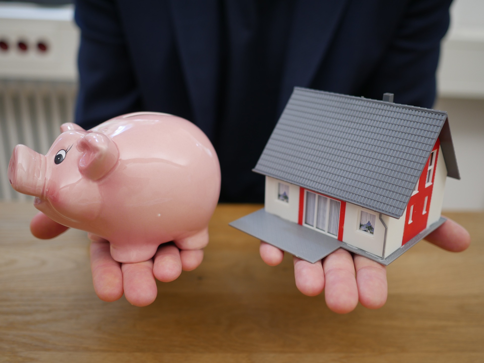 man holding piggy bank and house